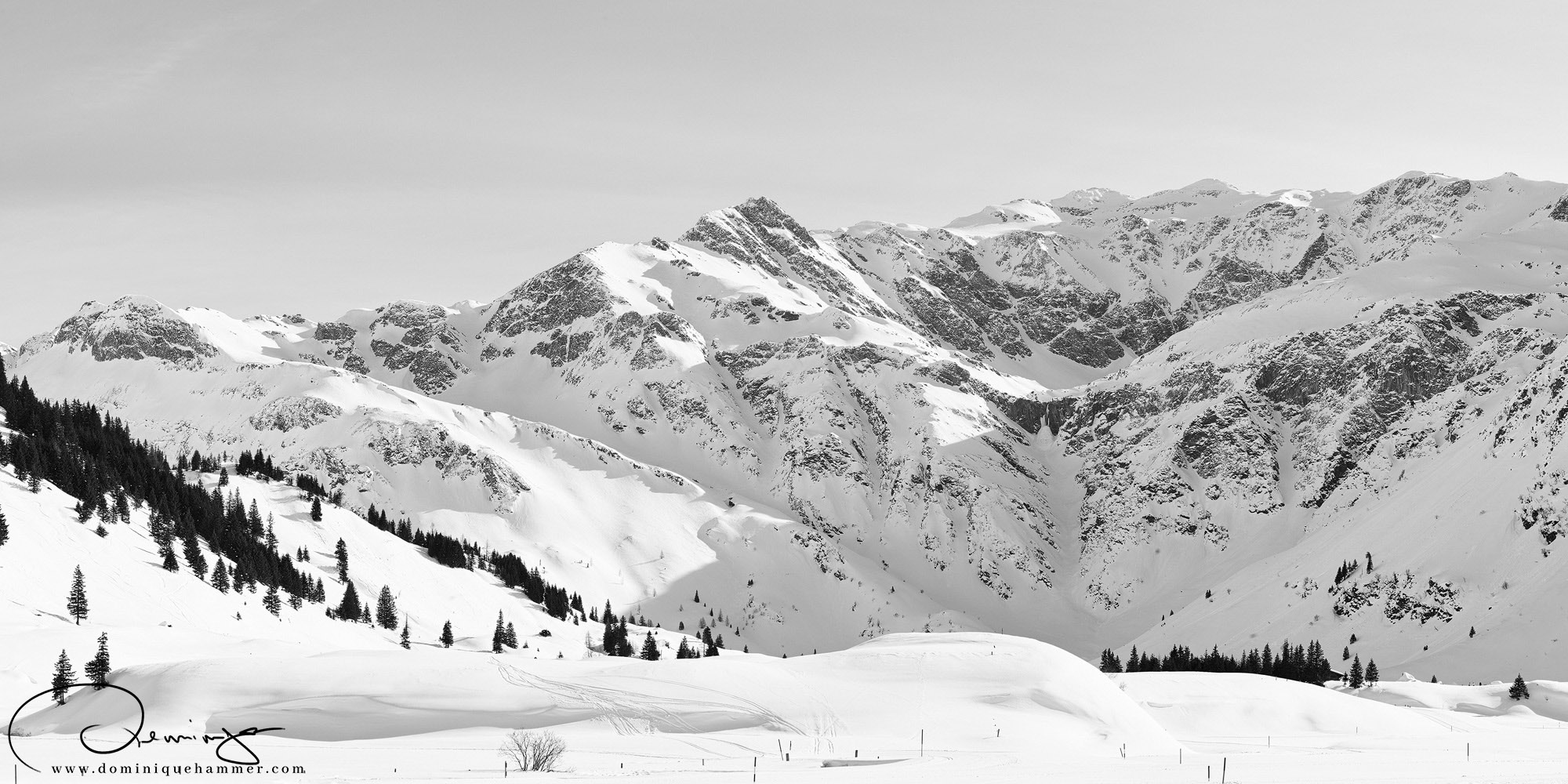 Eine schwarz weiss Aufnahme der verschneiten Berge in Sportgastein von Fotograf Dominique Hammer