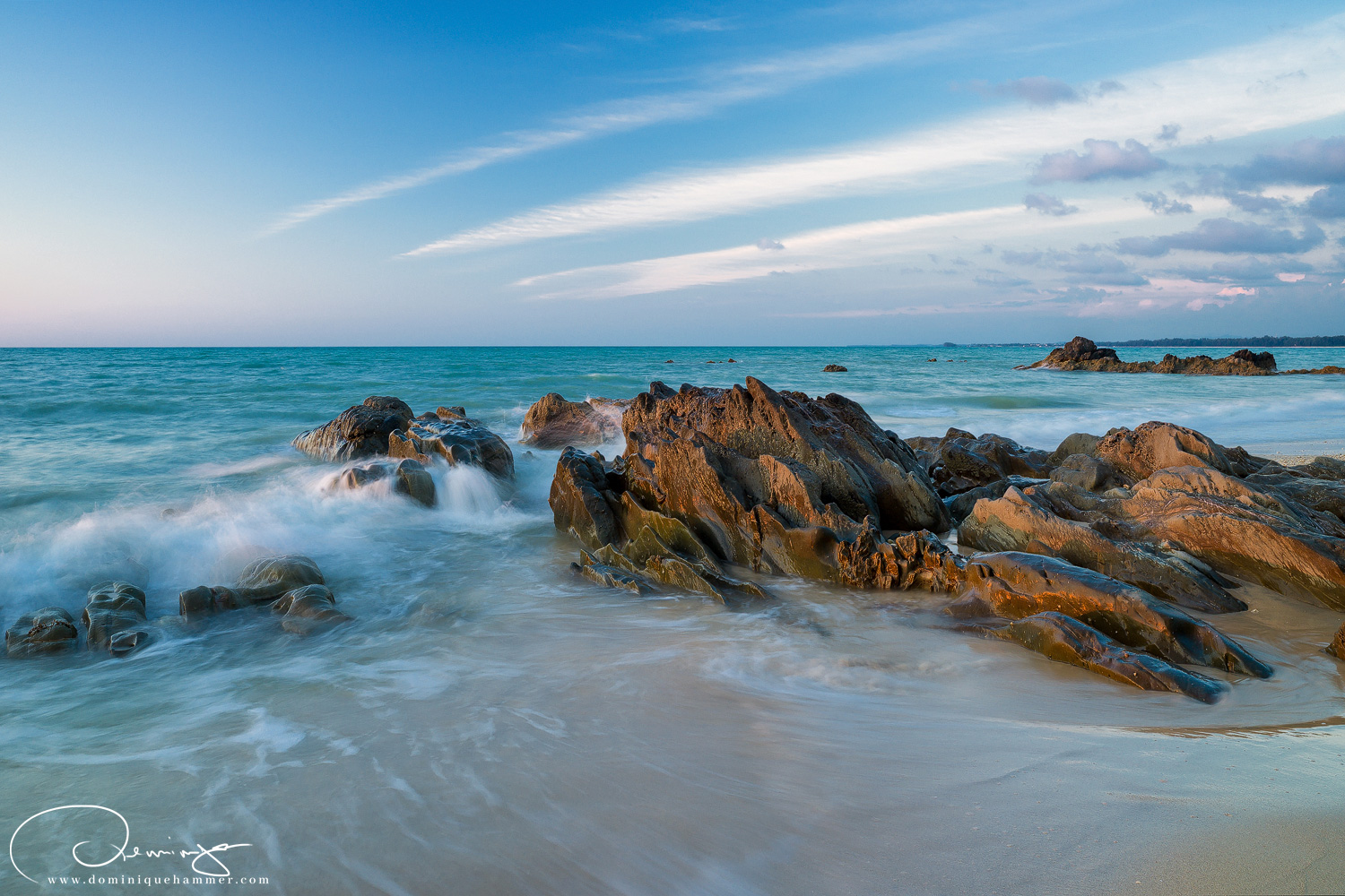 Eine Welle am Strand von Khao Lak brandet gegen einen Felsen von Fotograf Dominique Hammer