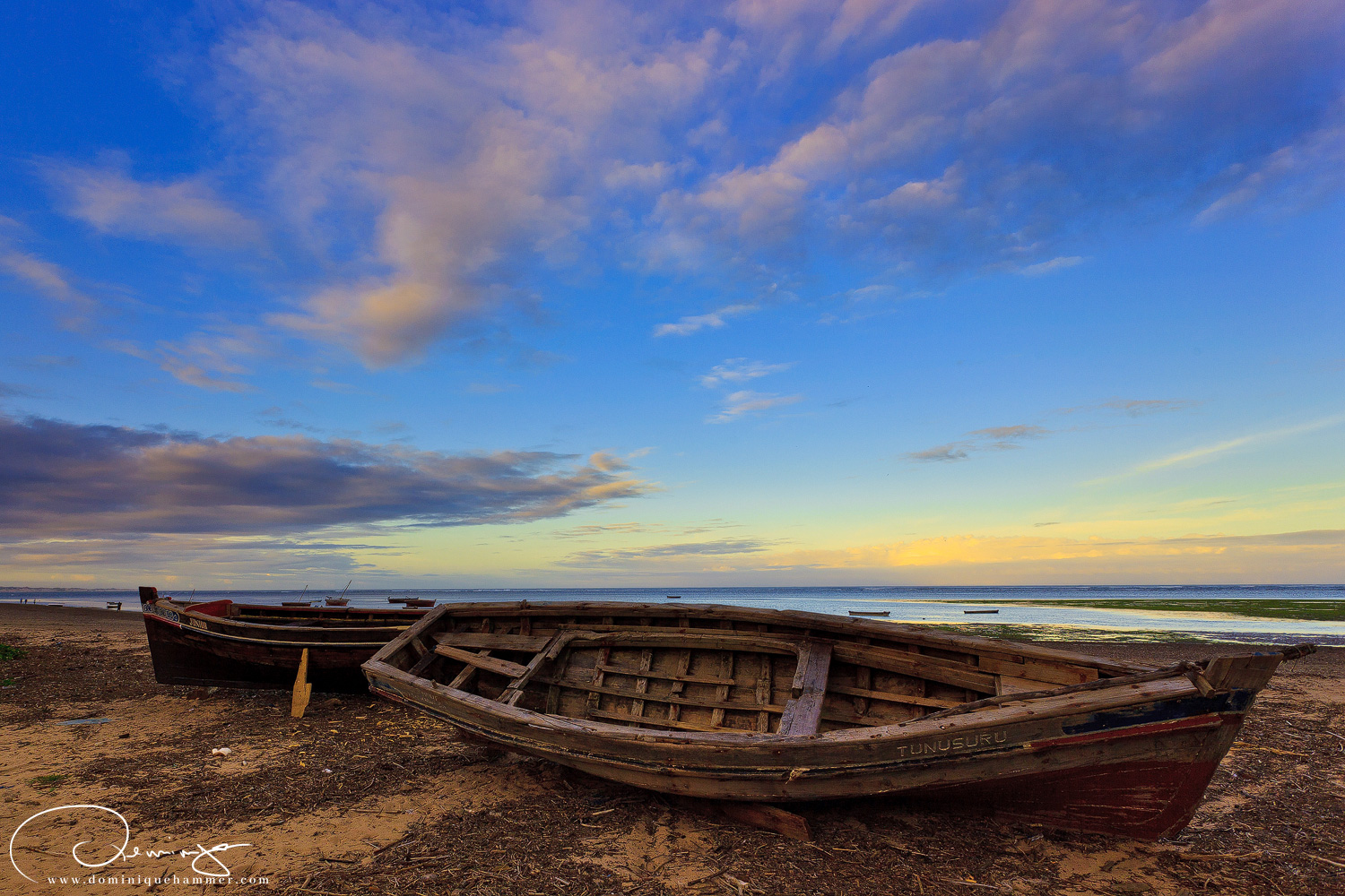 Zwei leere Boote am Strand von Vasco da Gama in Kenia von Fotograf Dominique Hammer