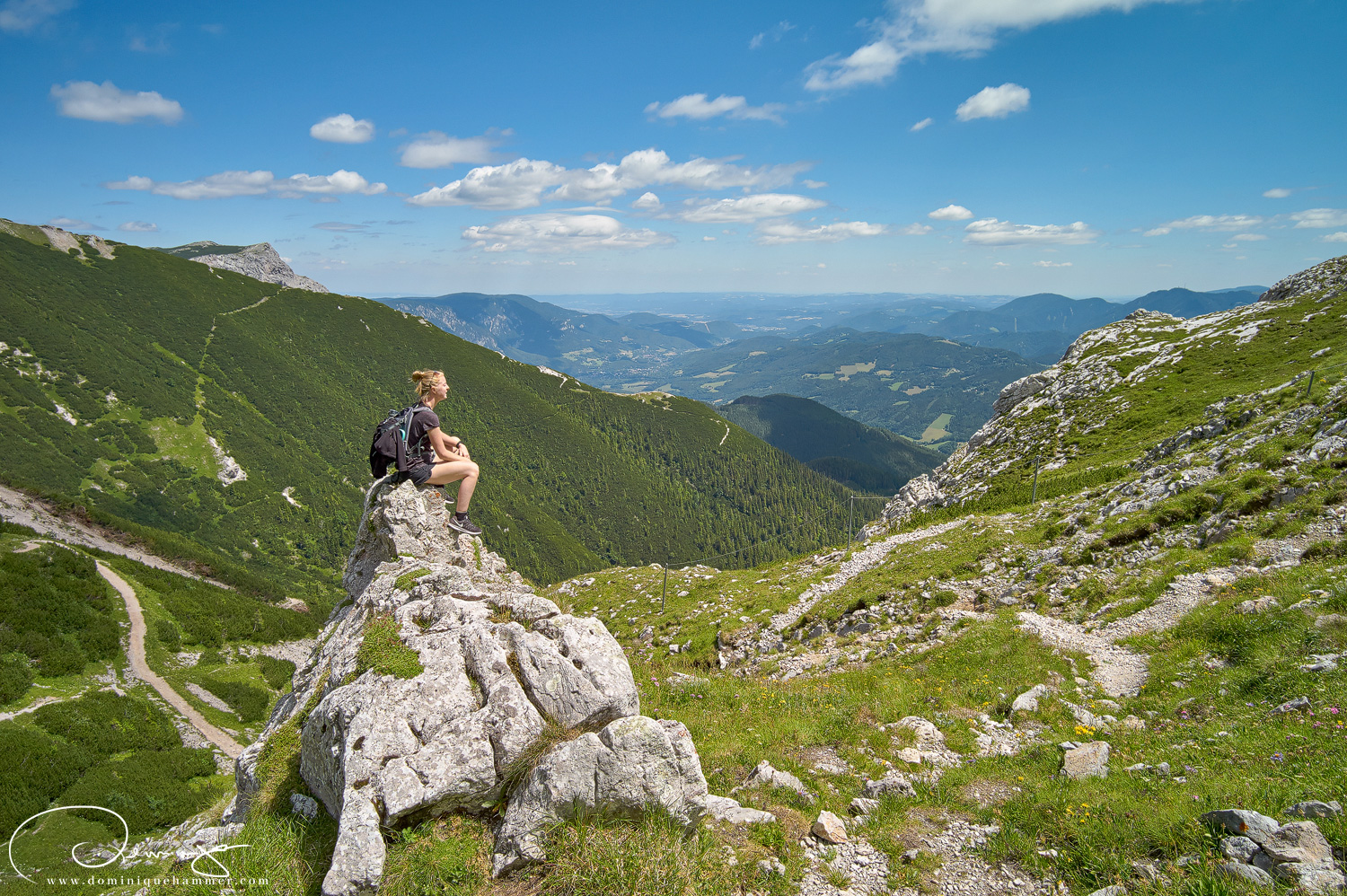 Eine junge Frau sitzt auf einem Fels auf der Rax von Fotograf Dominique Hammer