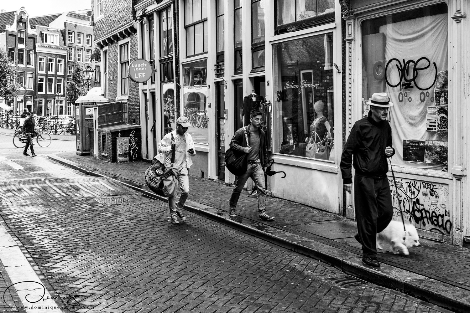 Menschen gehen auf der Stra&szlig;e in Amsterdam von Fotograf Dominique Hammer