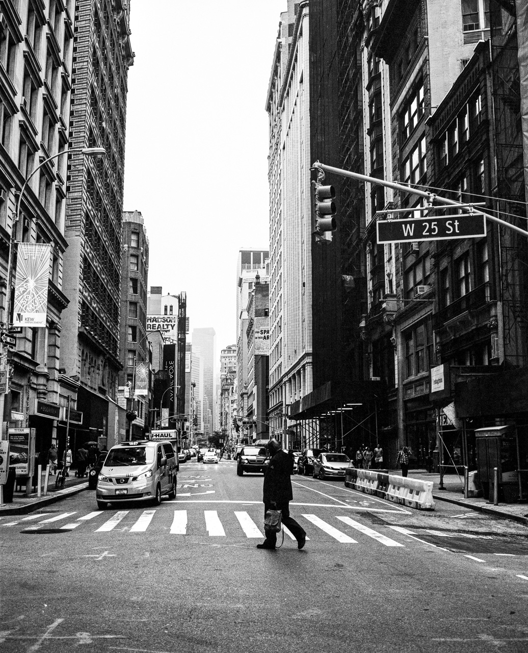 Ein Mann &uuml;berquert eine Stra&szlig;e in Manhattan, New York von Fotograf Dominique Hammer