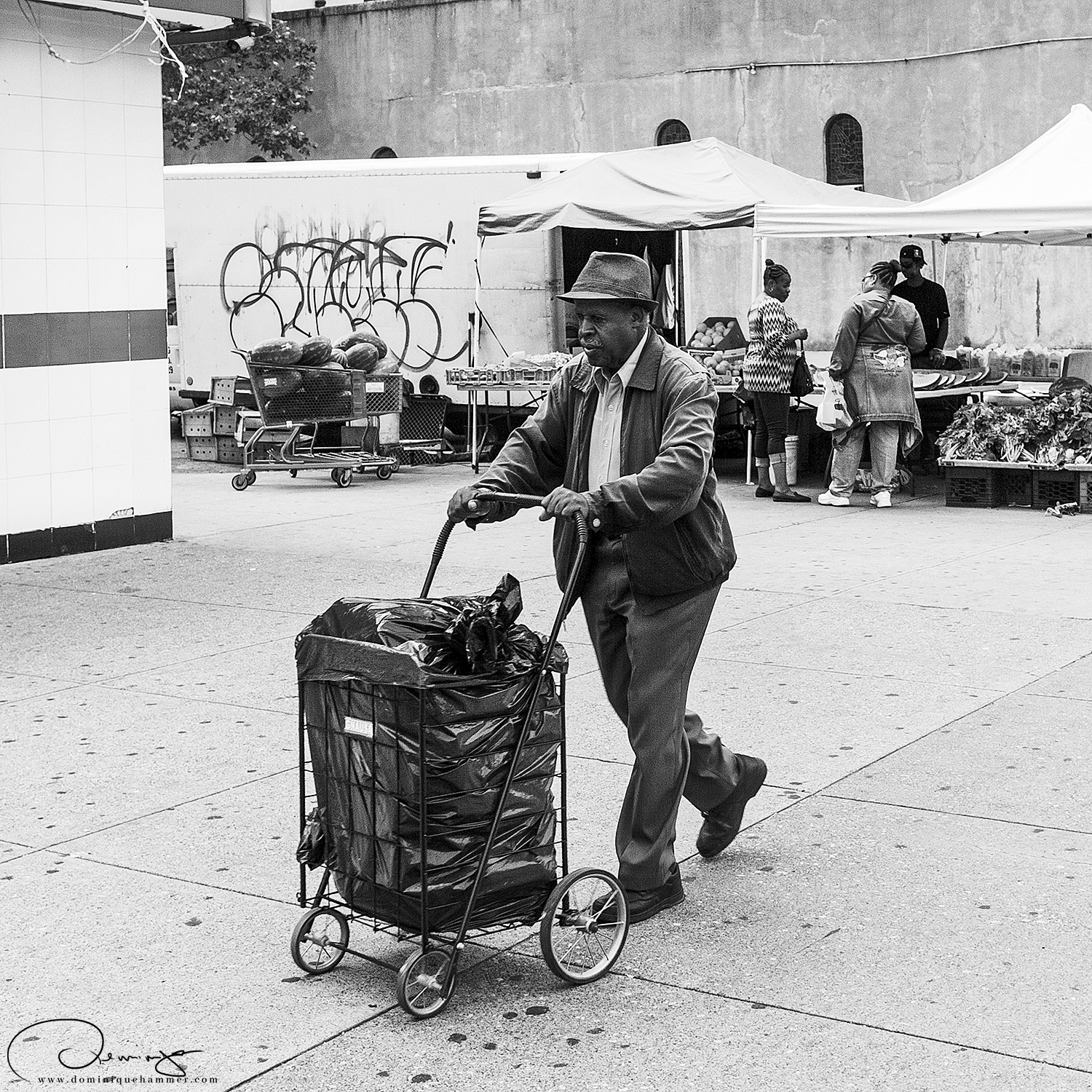 Ein Mann mit einem Rollwagen in Harlem in Manhattan, New York von Fotograf Dominique Hammer