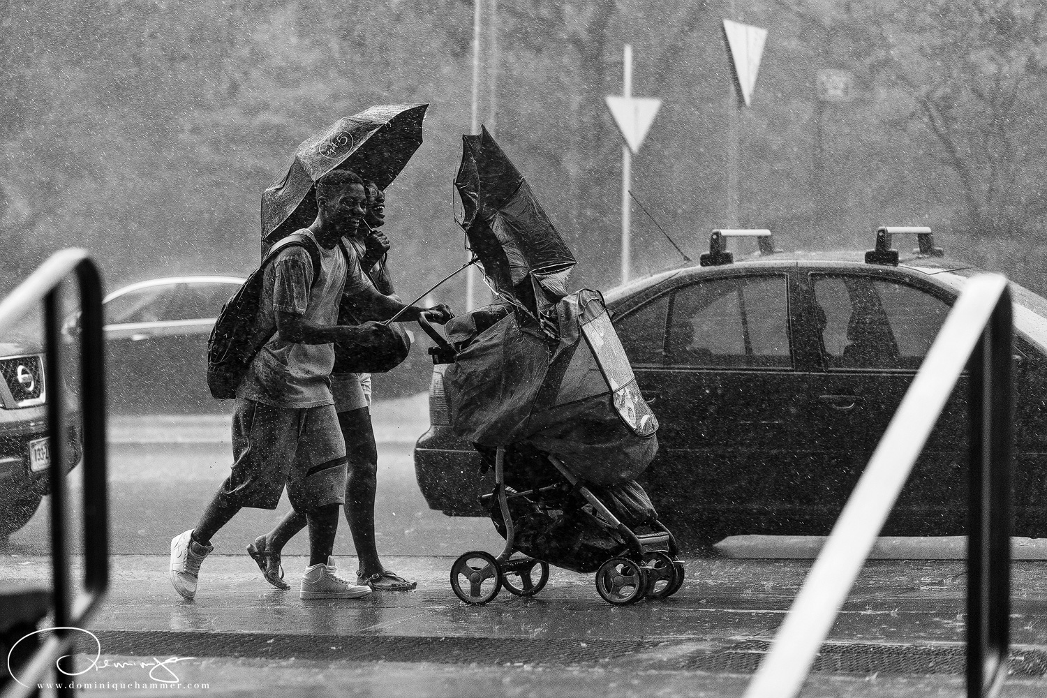 Ein junges Paar mit Kinderwagen bei starkem Regen in Manhattan, New York von Fotograf Dominique Hammer