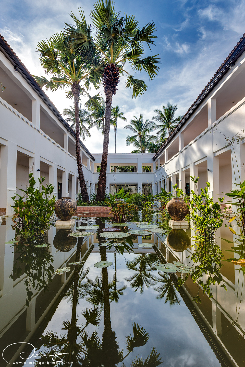 Der innenhof eines Hauses mit einem Brunnen und Palmen in Khao Lak, von Fotograf Dominique Hammer